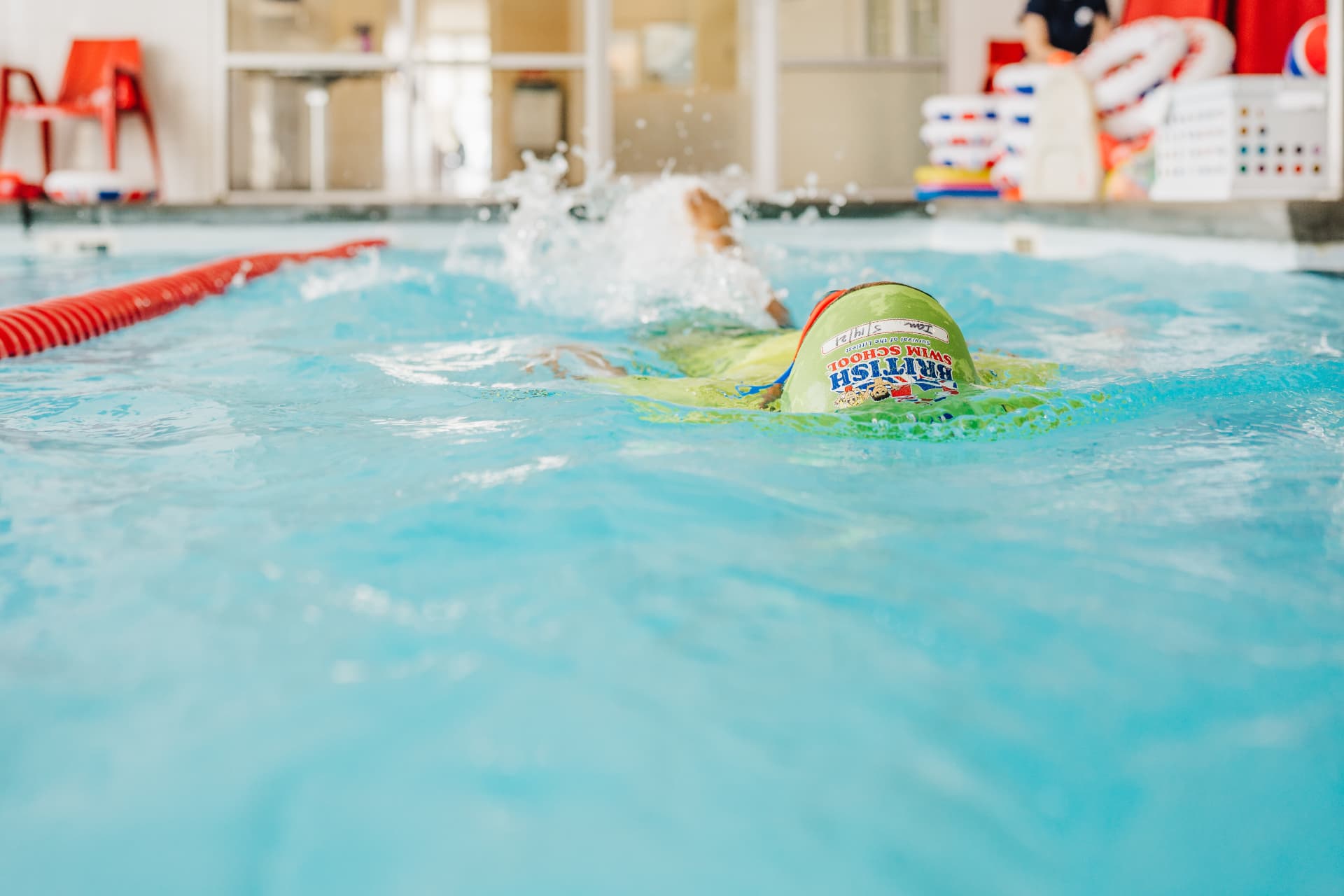 A young swimmer practicing strokes in a British Swim School pool